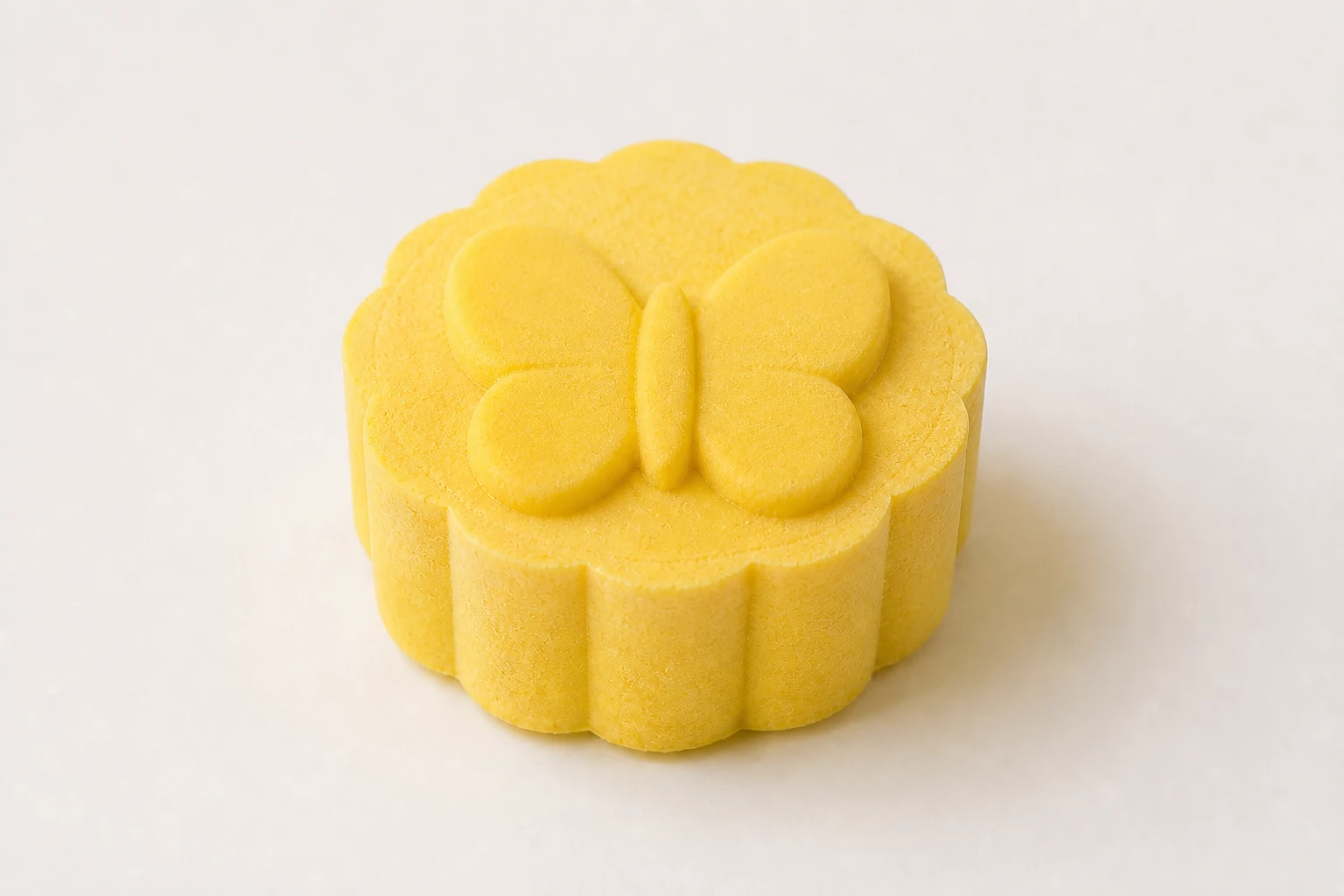 Yellow bath bomb with a raised butterfly design