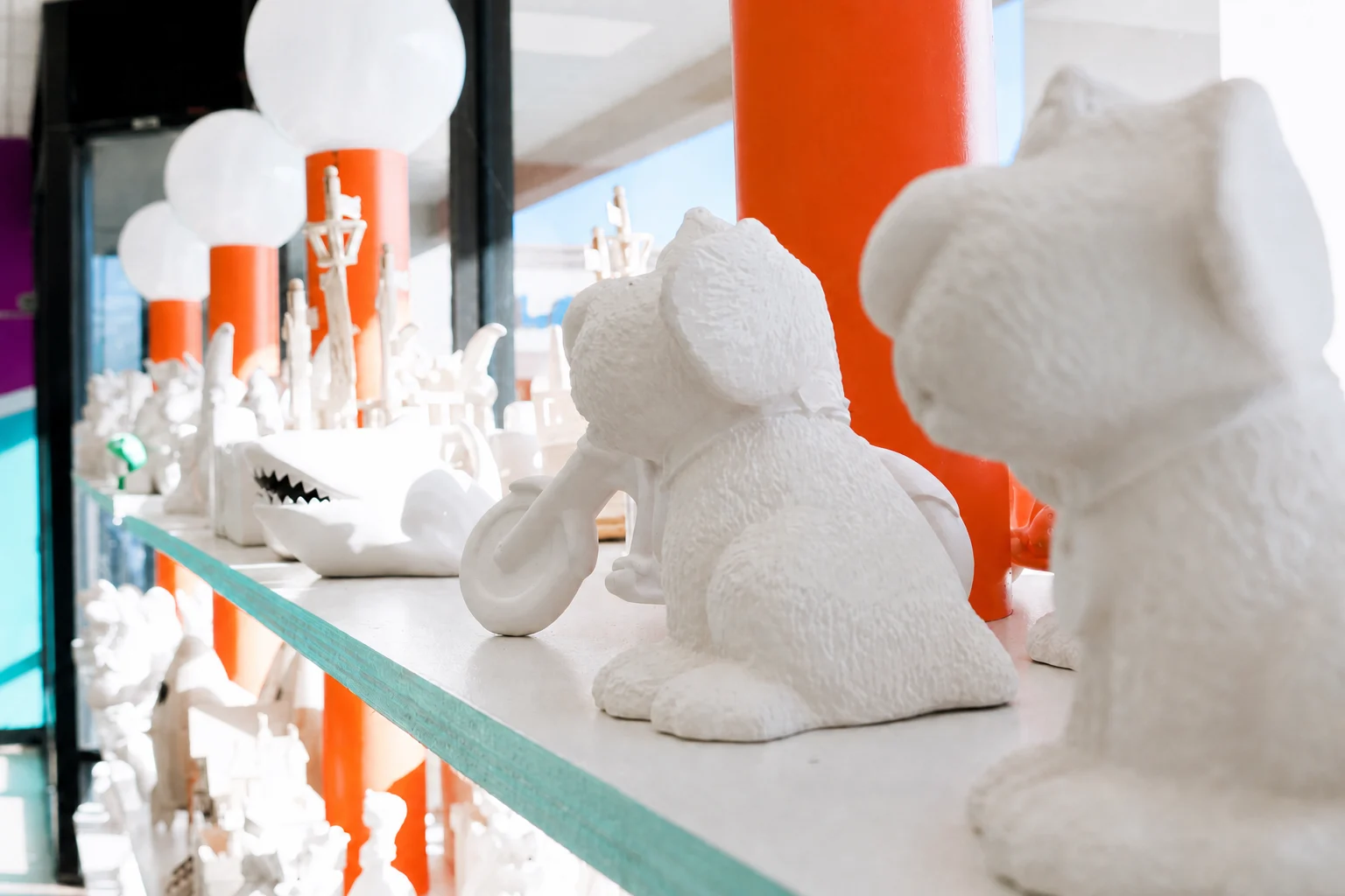 Unpainted ceramic animals and figurines on the studio display rack